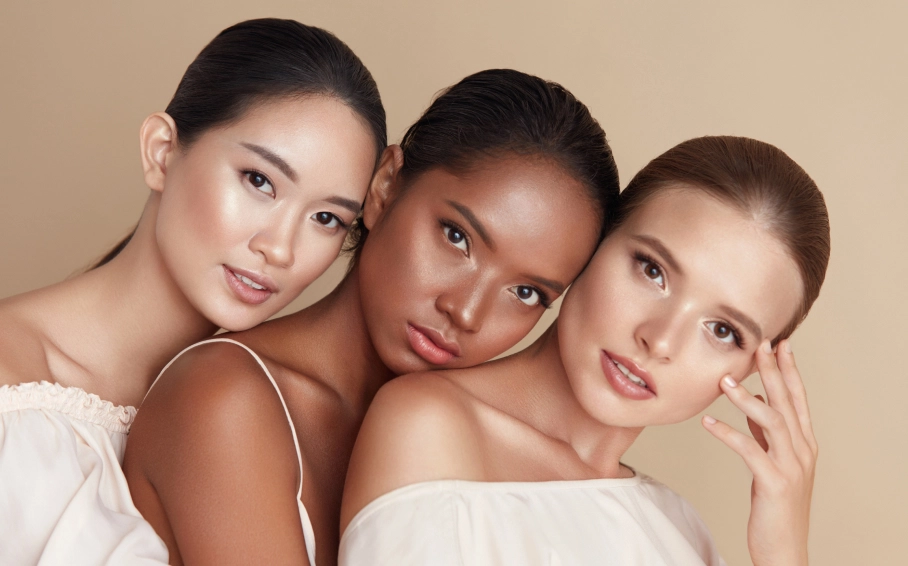 Three women with diverse skin tones showcasing healthy, glowing skin after cosmetic dermatology treatments in San Antonio